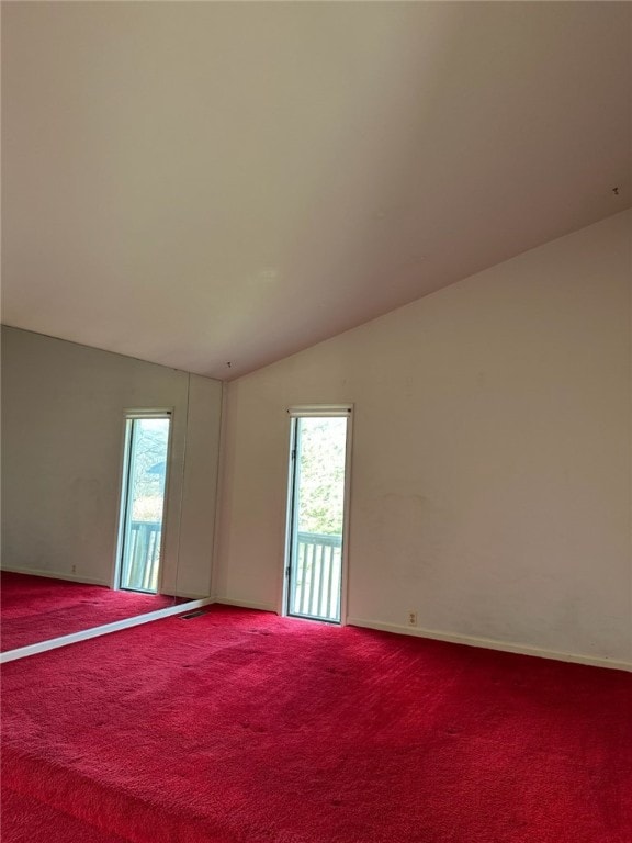 spare room featuring lofted ceiling and carpet flooring