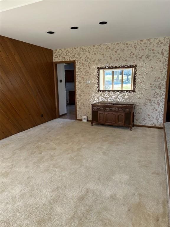 unfurnished room featuring wallpapered walls and light colored carpet