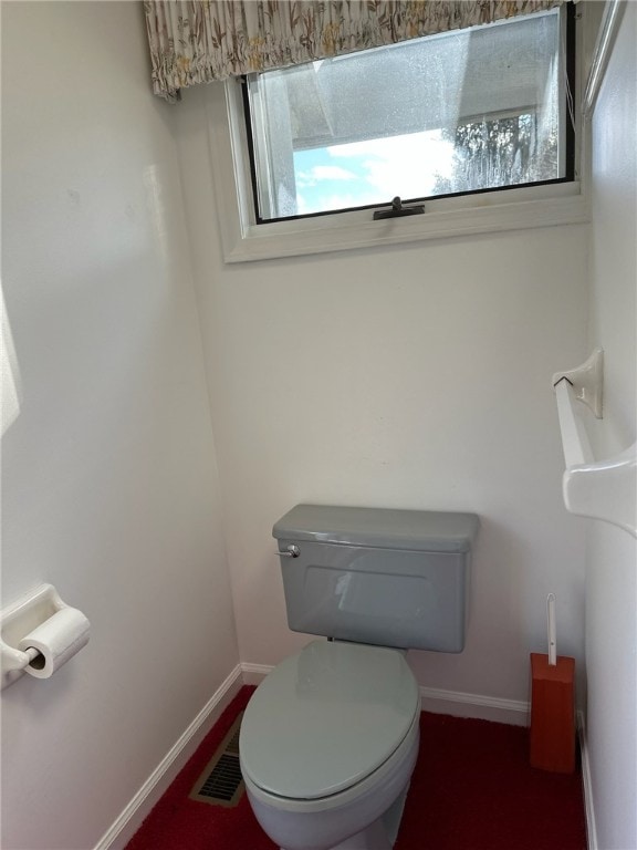 bathroom with toilet, visible vents, and baseboards