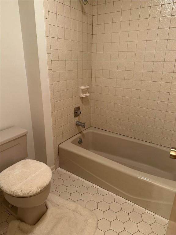 full bath featuring tile patterned flooring, tub / shower combination, and toilet