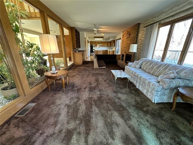 living area with visible vents and dark carpet