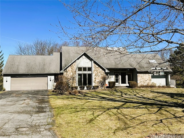 mid-century inspired home with a front lawn, driveway, stone siding, roof with shingles, and a garage