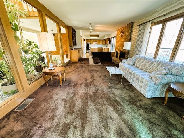 living area with visible vents and dark carpet