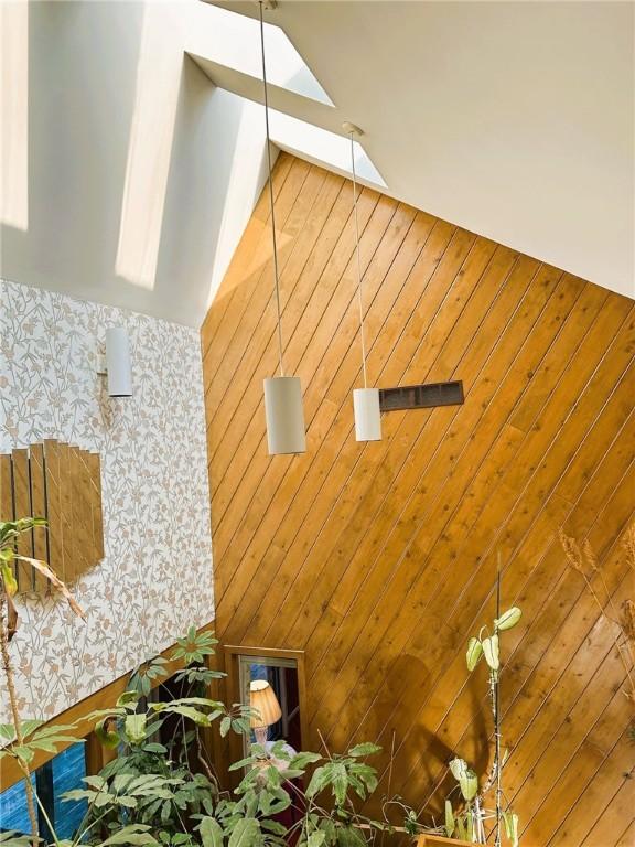 interior details featuring a skylight and wallpapered walls