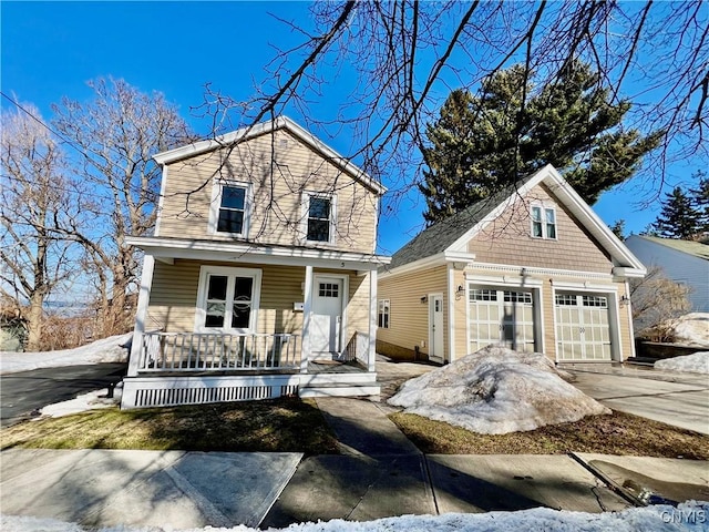 view of front of home featuring a porch, concrete driveway, and a garage