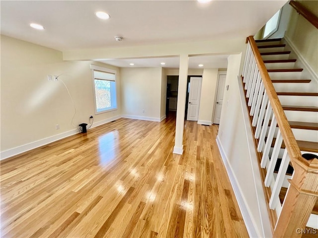 below grade area featuring recessed lighting, stairs, light wood-type flooring, and baseboards