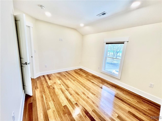 unfurnished room featuring visible vents, light wood-style flooring, recessed lighting, baseboards, and lofted ceiling