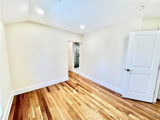 spare room with recessed lighting, light wood-style flooring, lofted ceiling, and baseboards