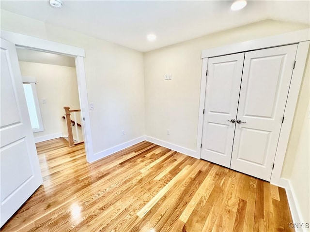 unfurnished bedroom with light wood finished floors, recessed lighting, a closet, and baseboards