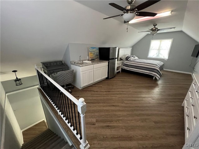 bedroom with lofted ceiling, a sink, freestanding refrigerator, baseboards, and dark wood-style flooring