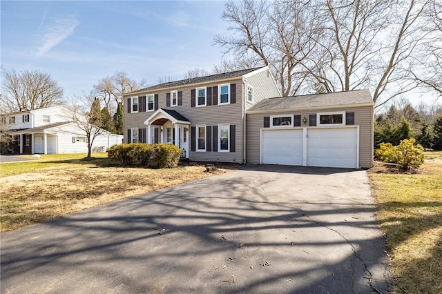 colonial inspired home featuring an attached garage and driveway