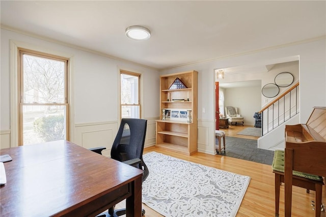 home office with a decorative wall, wood finished floors, a wainscoted wall, and ornamental molding