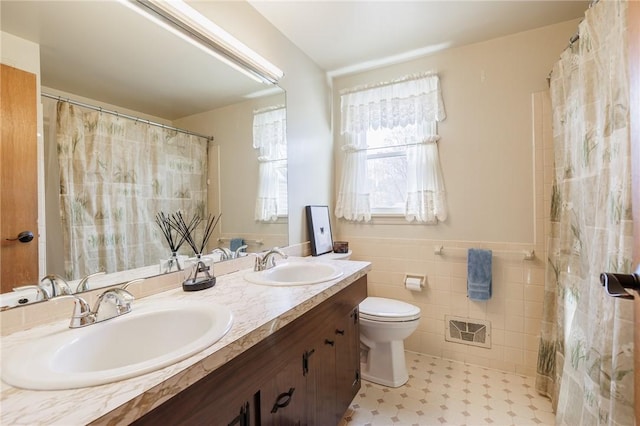 full bath featuring tile walls, toilet, visible vents, and a sink