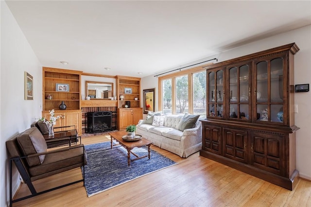 living area with light wood-style flooring and a fireplace