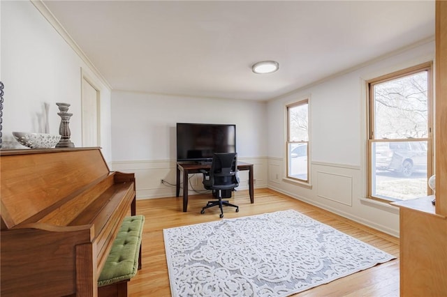 office area featuring light wood-style flooring, ornamental molding, and wainscoting