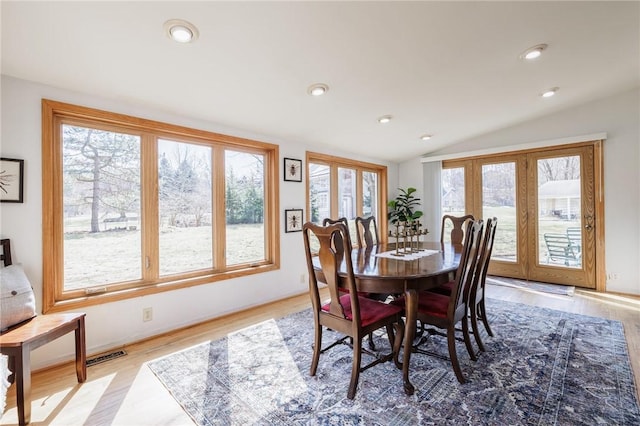 dining space with recessed lighting, lofted ceiling, and wood finished floors