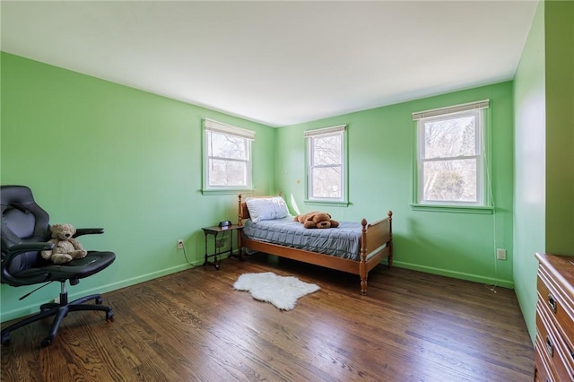 bedroom with baseboards and wood finished floors