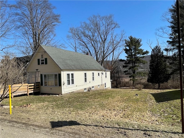 view of front of property with a front yard, a chimney, and a shingled roof