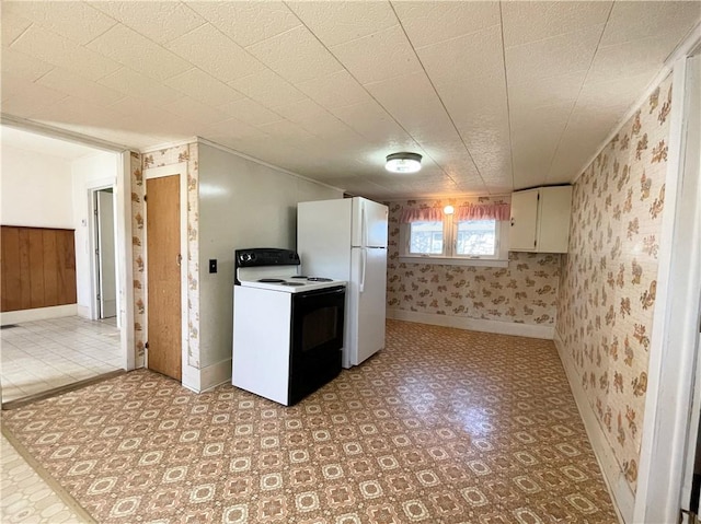 kitchen with electric range, light floors, wallpapered walls, and freestanding refrigerator