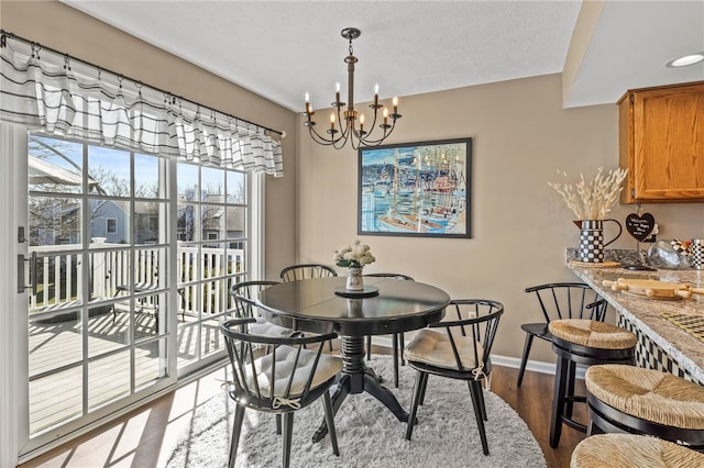 dining area with baseboards, dark wood-type flooring, and an inviting chandelier