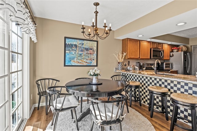 dining area with a notable chandelier, baseboards, and wood finished floors