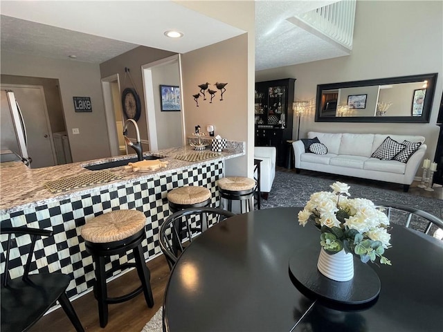 dining room with recessed lighting, a textured ceiling, and wood finished floors