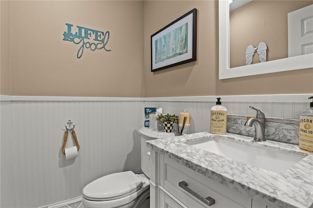 bathroom with wainscoting, toilet, and vanity