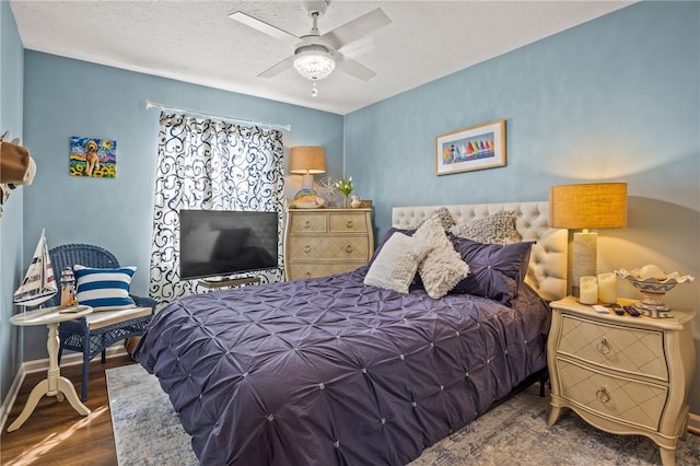 bedroom with ceiling fan, baseboards, a textured ceiling, and wood finished floors