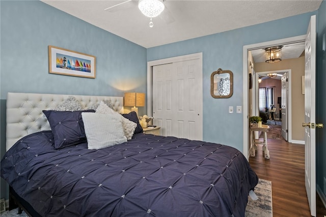 bedroom with a ceiling fan, wood finished floors, a closet, and baseboards