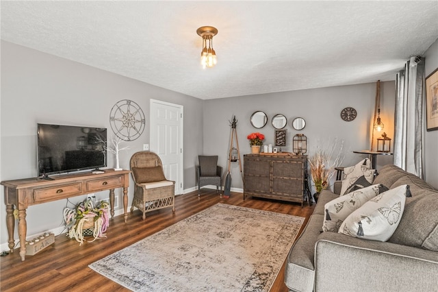 living area featuring wood finished floors, baseboards, and a textured ceiling