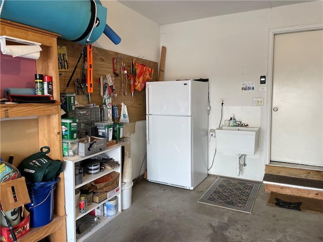 kitchen with concrete floors and freestanding refrigerator