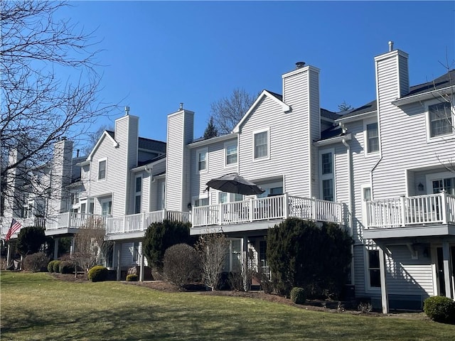 rear view of property with a yard, a residential view, and a chimney