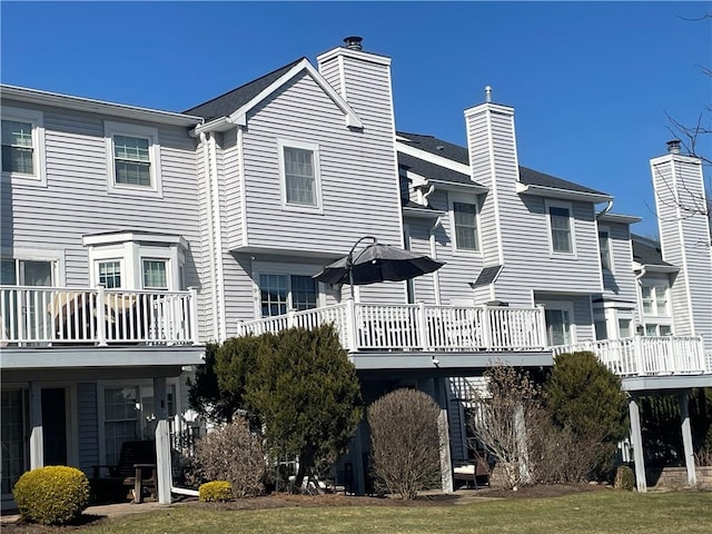 rear view of property with a lawn and a chimney