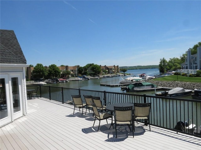 wooden deck with outdoor dining area and a water view