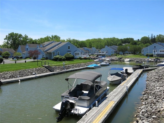 view of dock featuring a residential view, a lawn, and a water view