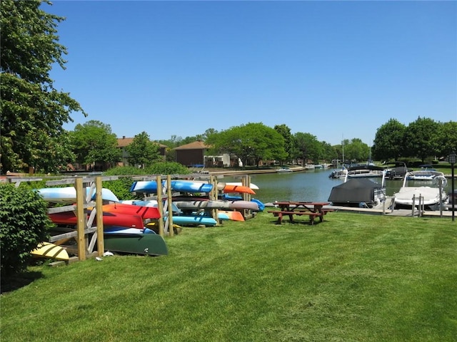 view of dock featuring a water view and a lawn