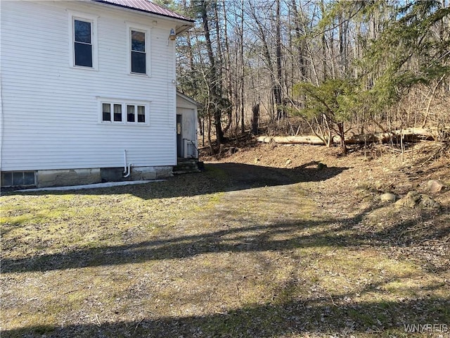 view of home's exterior with entry steps and metal roof