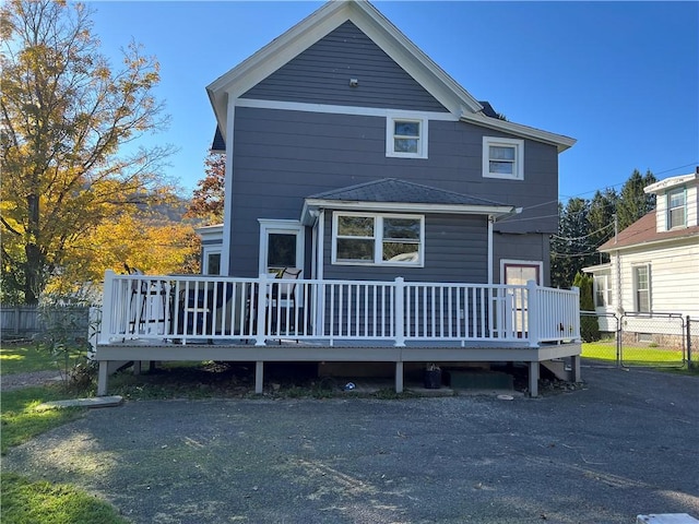 back of house featuring a deck, a gate, and fence