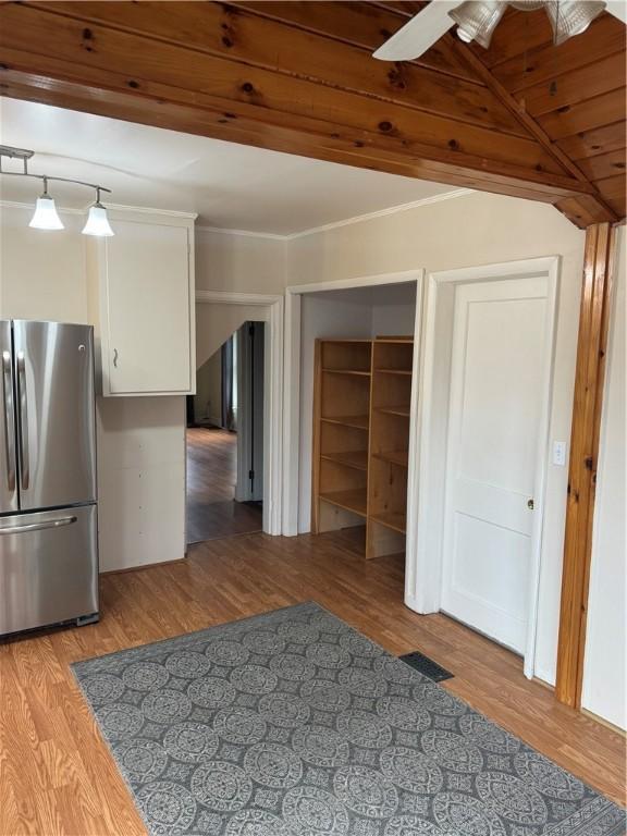 kitchen with visible vents, light wood-style flooring, a ceiling fan, white cabinetry, and freestanding refrigerator