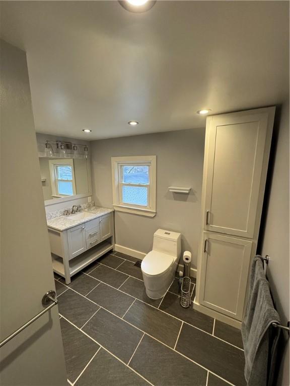 bathroom featuring tile patterned flooring, baseboards, toilet, recessed lighting, and vanity