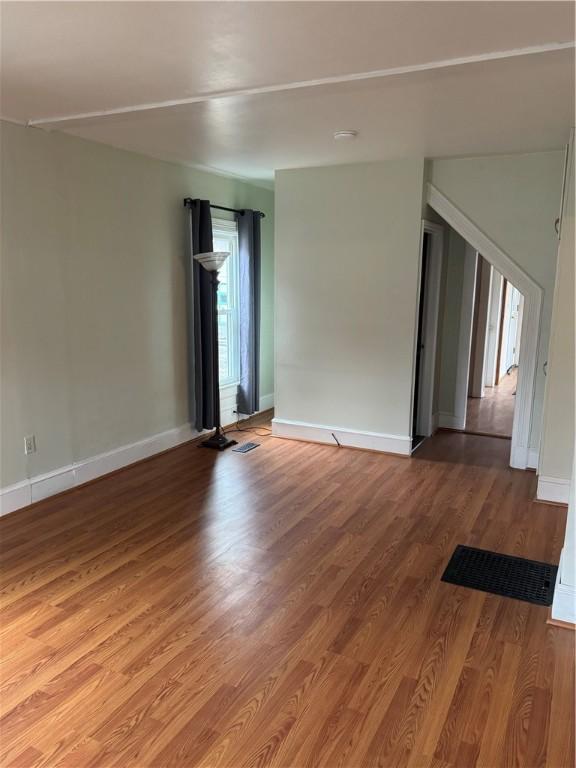 unfurnished room with light wood-type flooring and baseboards