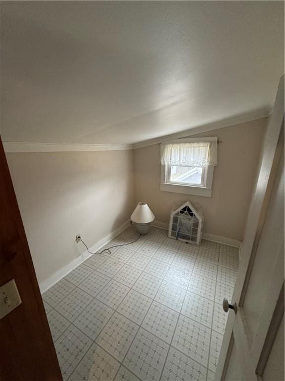 interior space with ornamental molding, baseboards, and vaulted ceiling