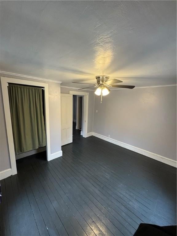 spare room with dark wood finished floors, baseboards, and ceiling fan