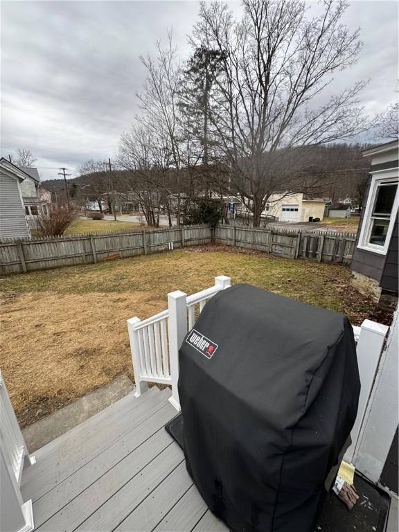 deck with grilling area and a fenced backyard