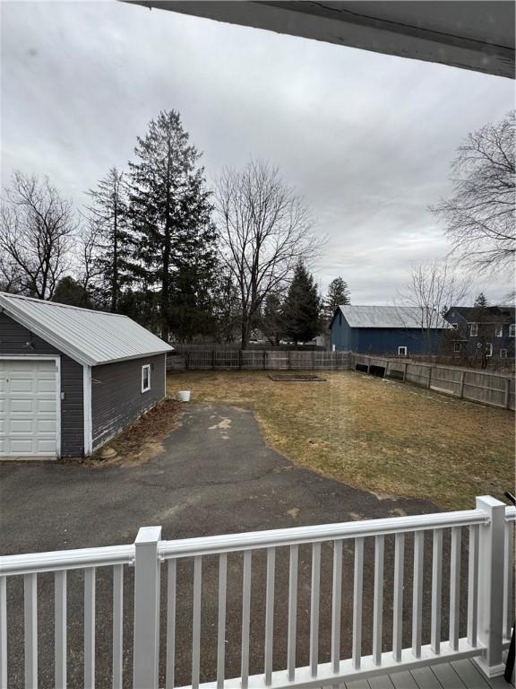 view of yard with an outbuilding, a fenced backyard, and a garage