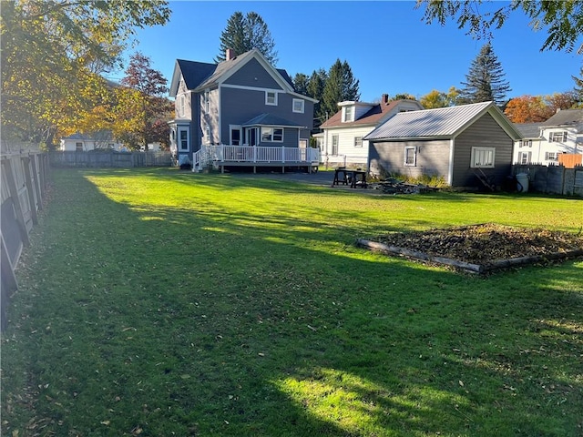 back of property with a yard, a deck, a residential view, and a fenced backyard