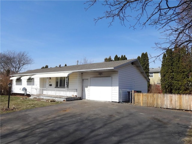 ranch-style home featuring fence, driveway, roof with shingles, a porch, and an attached garage