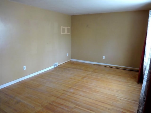 unfurnished room with visible vents, baseboards, and light wood-style floors