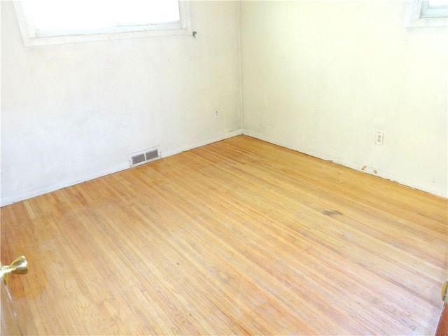 empty room featuring light wood-type flooring and visible vents