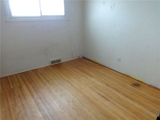 unfurnished room with visible vents and light wood finished floors